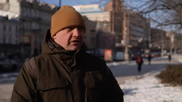 Oleksandr stands outside in Kyiv on a sunny day