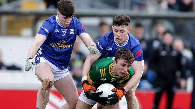 Cavan duo Cian Reilly and Dara McVeety put pressure on Meath's Sean Coffey