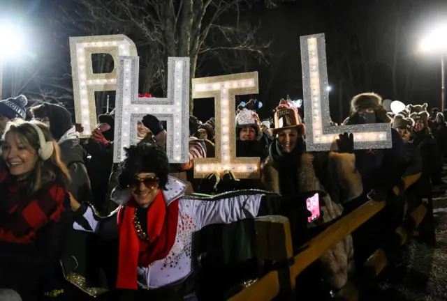 People hold up Phil name sign as the Groundhog Day festivities begin