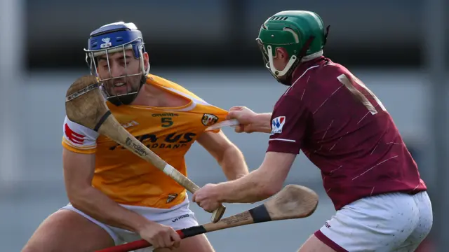 Antrim's Scott Walsh has his shirt tugged by David Williams