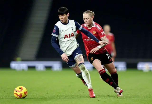 Ashleigh Neville runs with the ball whilst under pressure from Leah Galton