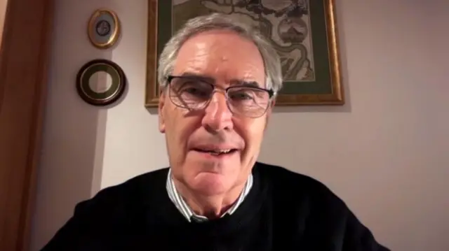 Headshot of Ignatieff speaking wearing a black jumper and glasses