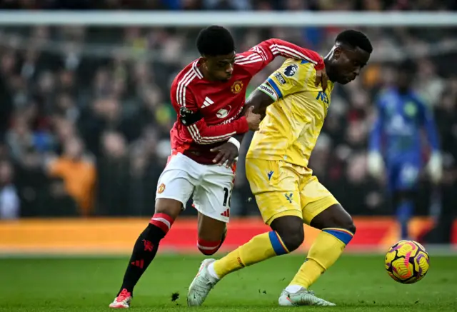Amad Diallo (L) fights for the ball with Crystal Palace's English defender #06 Marc Guehi