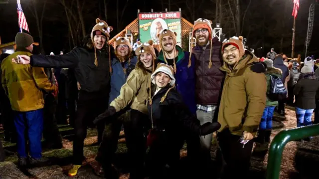 People poses for a picture, on the day groundhog Punxsutawney Phil makes his prediction on how long winter will last