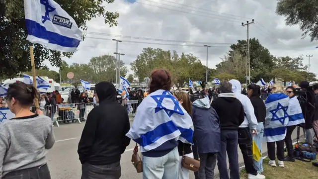 Crowds, many wearing or holding Israel flags, outside the Abu Kabir forensic institute