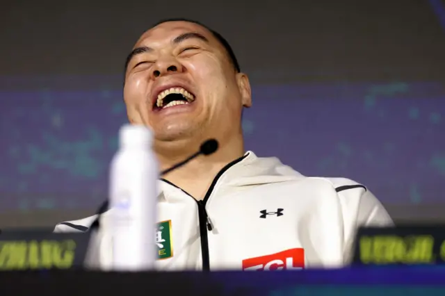 Zhilei Zhang laughs at a news conference