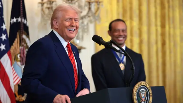 President Donald Trump and Tiger Woods on stage at a White House event marking Black History Month