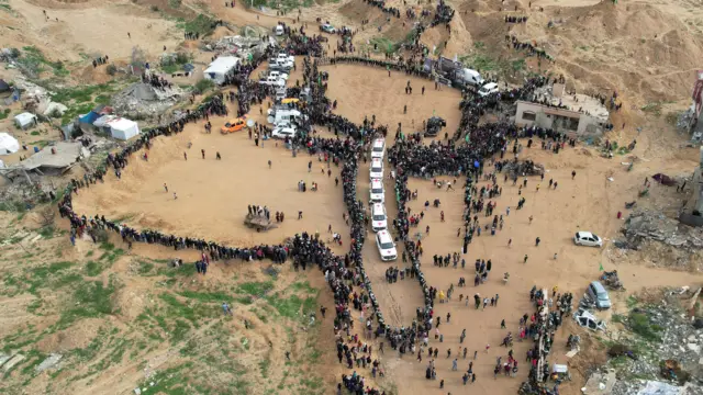 A drone view shows Palestinians and militants gathering around Red Cross vehicles