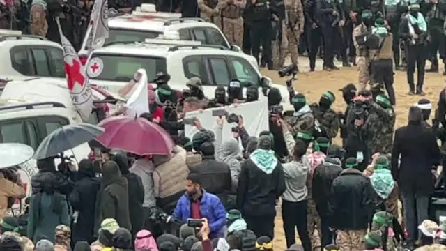 A Red Cross Vehicle surrounded by screens, with crowds gathered around them