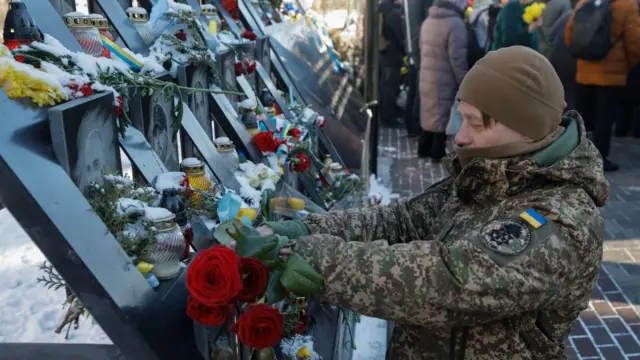 A man pays pay tribute to the activists killed during anti-government protests in 2014 - he places a red rose at a memorial site