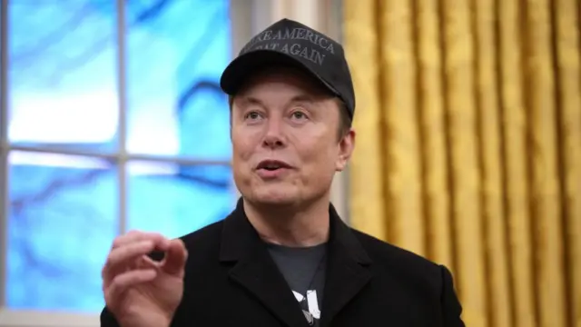 Elon Musk speaks while wearing a "Make America Great Again" cap