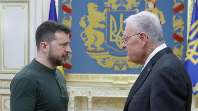 Zelensky meets with Kellogg in an ornate room with a Ukrainian flag in the background