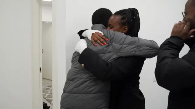 Avera Mengistu hugs his sister at the initial reception point.