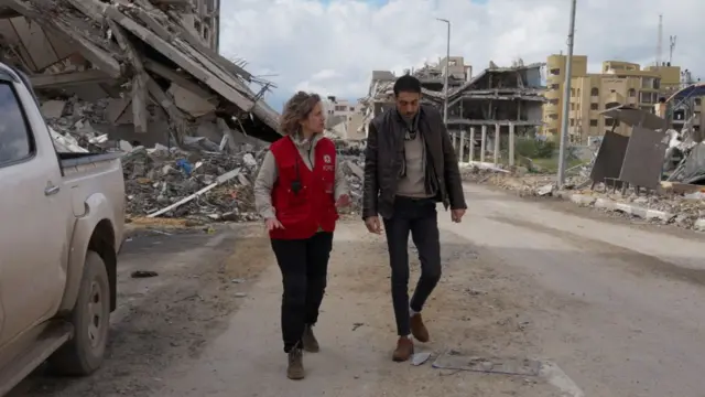 Hisham al-Sayed walks with a member of the Red Cross in Gaza