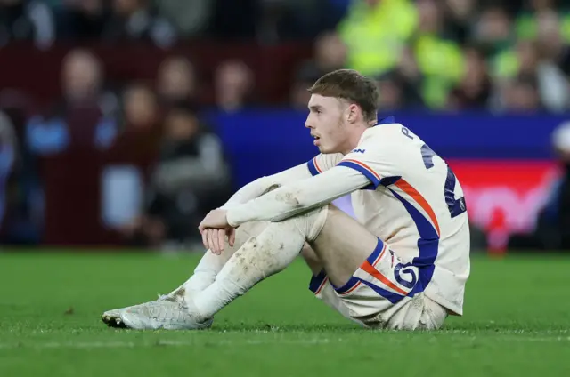 Palmer sits on the floor with a dejected expression