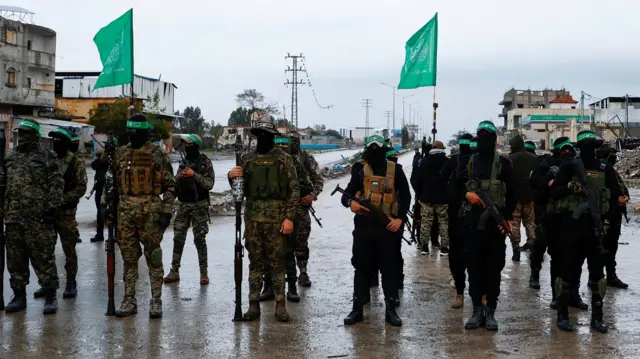 Palestinian Hamas militants stand guard on the day of the handover of hostages, including those held in Gaza since the deadly October 7 2023 attack