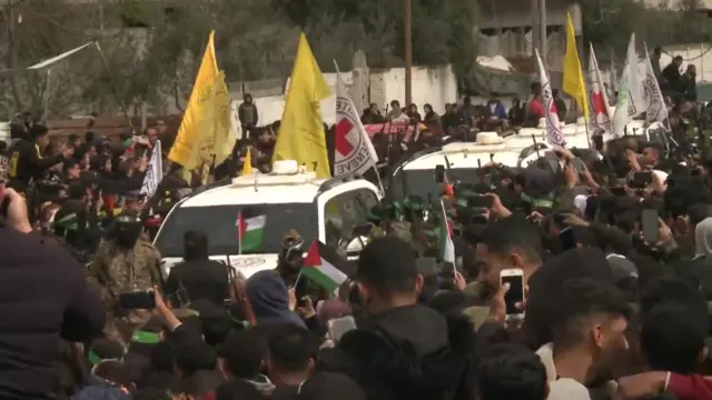 Red Cross vehicles among a crowd in Nuseirat