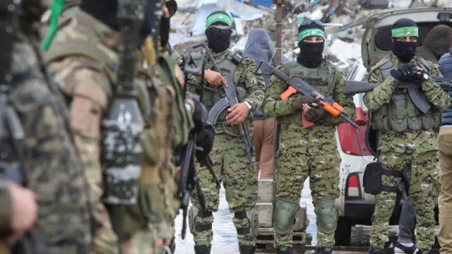 Palestinian Hamas militants stand guard on the day of the handover of hostages, including those held in Gaza since the deadly October 7 2023