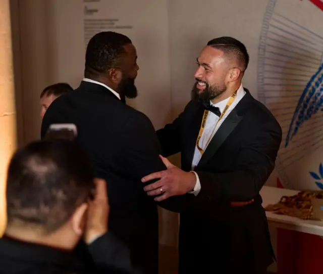 Joseph Parker smiles and holds the arm of Martin Bakole