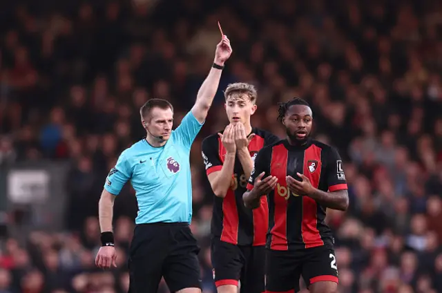 Referee Michael Salisbury shows a yellow card to Illya Zabarnyi