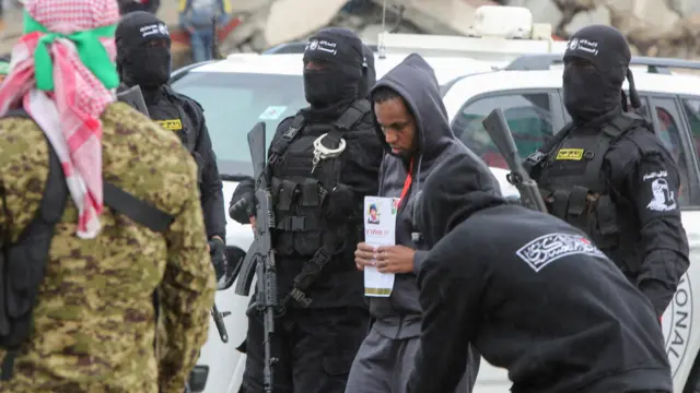 Avera Mengistu, who entered Gaza around a decade ago and has been held there since, is escorted by Palestinian Hamas militants as part of a ceasefire and a hostages-prisoners swap deal between Hamas and Israel, in Rafah, in the southern Gaza Strip