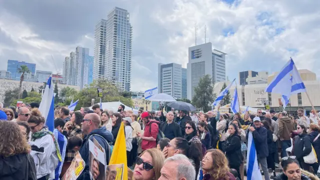 Dozens of Israelis gathered in Hostages Square, some carrying flags, ahead of the release.