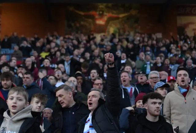 Villa fan punches the air as he cheers in the stands