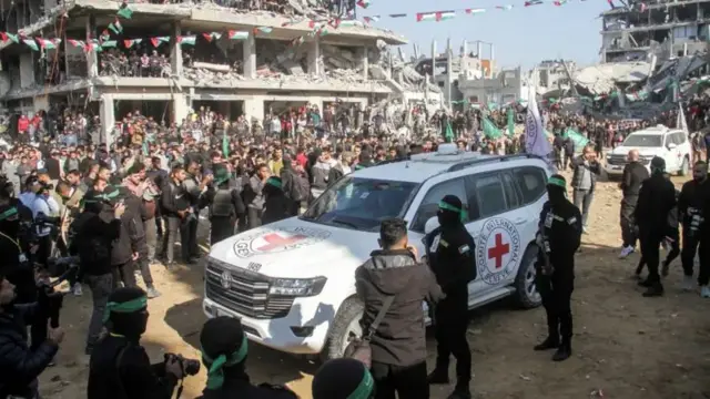 ICRC vehicle surrounded by crowds and armed militants