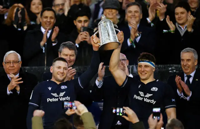 Finn Russell and Rory Darge of Scotland lift the Calcutta Cup after defeating England