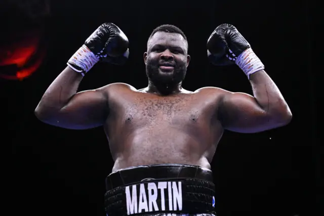 Martin Bakole holds up his fists and is wearing boxing gloves