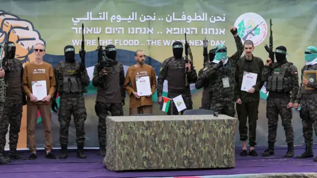 three hostages on a stage in Deir al-Balah, central Gaza, before their release