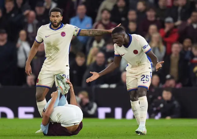 James and Caicedo shout as Watkins lies on the floor holding his foot