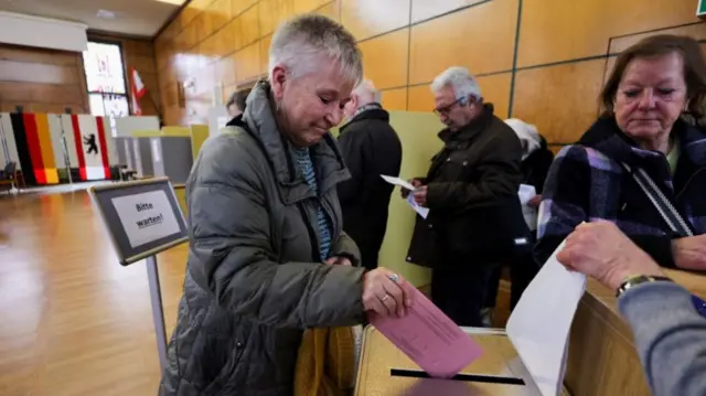 A woman casting her vote at a polling station.