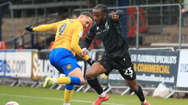 Wrexham's Seb Revan takes on Mansfield's Jordan Bowery