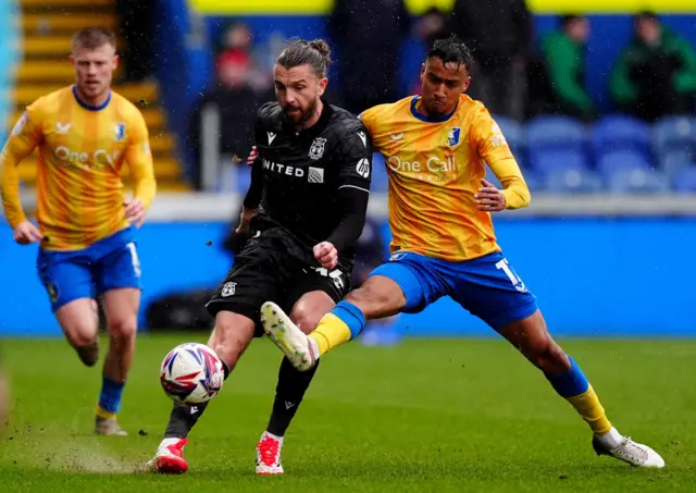 Wrexham's Jay Rodriguez (left) and Mansfield Town's Keanu Baccus (right) battle for the bal