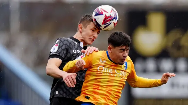 Mansfield Town's Caylan Vickers and Wrexham's Max Cleworth battle for the ball