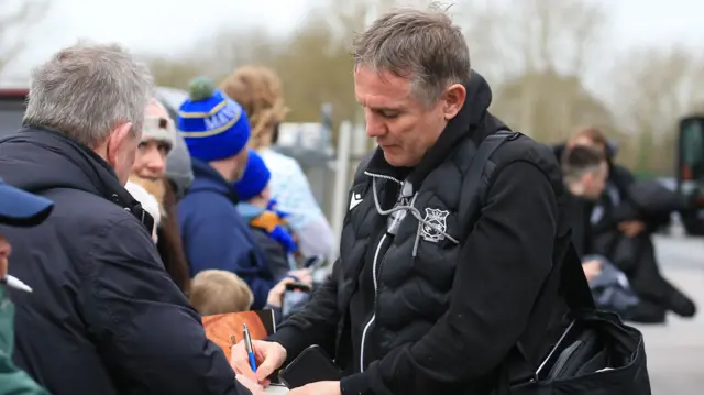 Wrehxam boss Phil Parkinson signs autographs