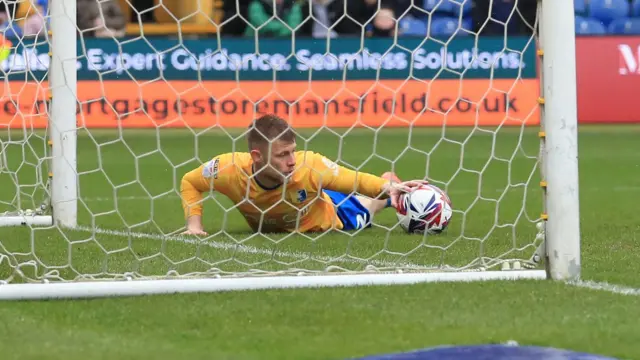 Mansfield's Calum Macdonald lies on the ground after scoring an own goal