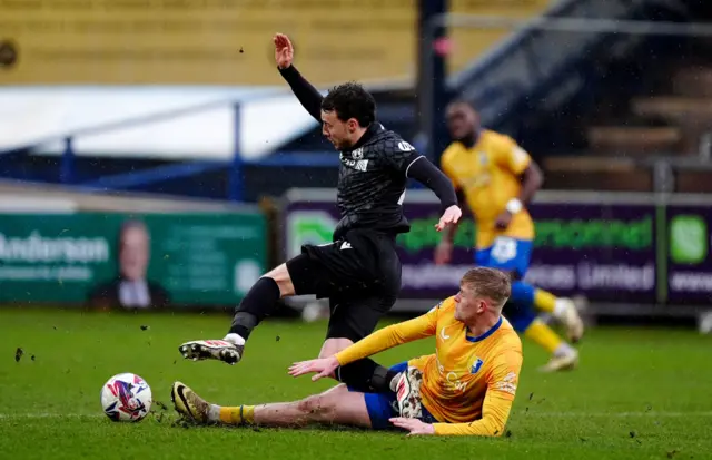 Wrexham's Oliver Rathbone (left) is tackled by Mansfield Town's Will Evans (right)