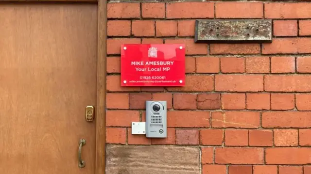 A red sign for Mike Amesbury outside his constituency office.