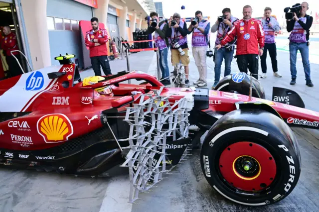 Photographs take pictures of Lewis Hamilton coming out of the Ferrari garage