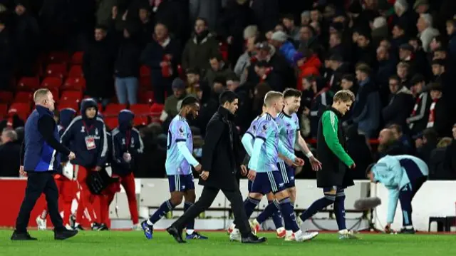 Mikel Arteta, Manager of Arsenal, and Arsenal players leave the pitch