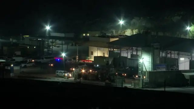 A shot from outside Ofer prison at nighttime - white vehicles can be seen parked up outside