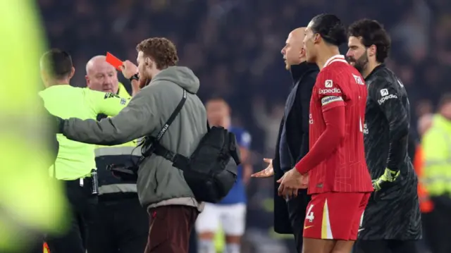 Michael Oliver shows Arne Slot a straight red card