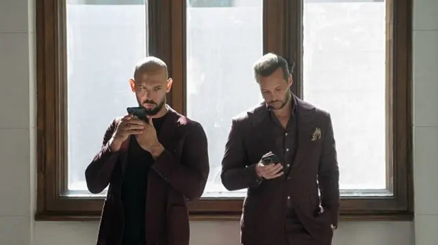 Andrew Tate (left) talks on the phone next to his brother Tristan Tate in the Court of Appeal on October 15, 2024 in Bucharest