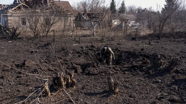 A police officer inspects a crated that appeared after a Russian airstrike., amid Russia’s attack on Ukraine, in Kramatorsk, Donetsk region