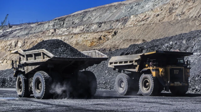 Haul trucks carry ore from an a mine in central Ukraine