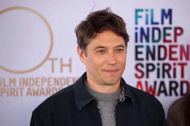 Sean Baker wearing a navy jacket and grey t-shirt at a film awards