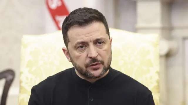 Volodymyr Zelensky sitting in Oval Office chair