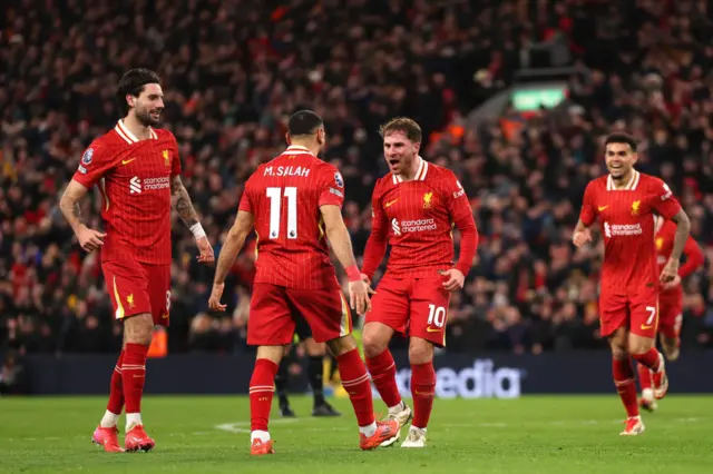 Alexis Mac Allister of Liverpool celebrates scoring his team's second goal with teammate Mohamed Salah during the Premier League match between Liverpool FC and Newcastle United FC at Anfield